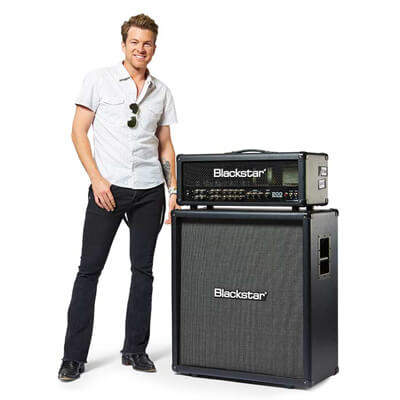 Joe Don Rooney of Rascal Flats standing next to a Blackstar Series One guitar amp head and cab