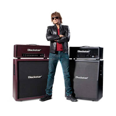 Richie Sambora of Bon Jovi standing next to a Blackstar Series One guitar amp head and cab