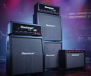 group of Blackstar Series One guitar amps on stage with mult-colored lights behind them
