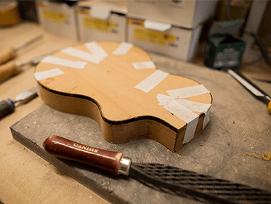guitar being made on progress beside a filing tool