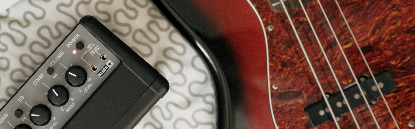 closeup view of a blackstar guitar amp and bass guitar pickup